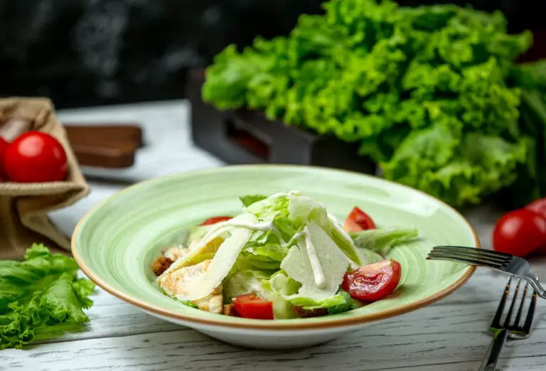 Sub in a Tub served in a clear bowl, featuring shredded lettuce, cucumbers, tomatoes, turkey slices, roast beef, chicken salami, red onions, banana peppers, feta cheese, and a drizzle of olive oil dressing, garnished with parsley.